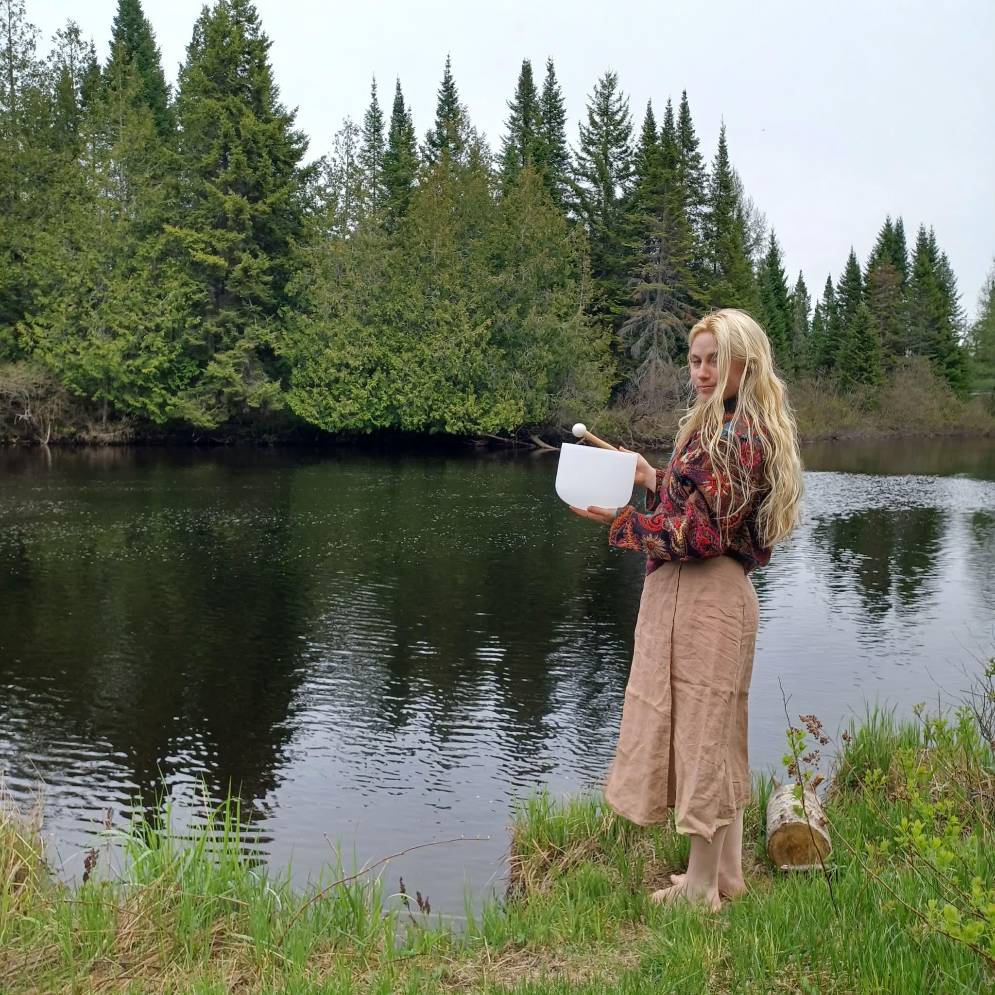 Élisa jouant un bol chantant au bord d'un lac